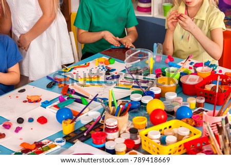 Child dough play in school. Plasticine for children. mold from plasticine in kindergarten .Creative chaos communications. Kids knead modeling clay with hands in preschool.