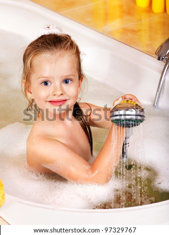 Little girl washing in bubble bath .