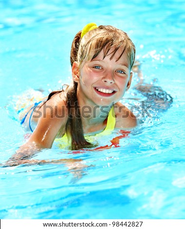 Child with armbands in swimming pool. Summer outdoor.