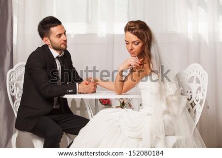 groom holds the hand of a shy bride