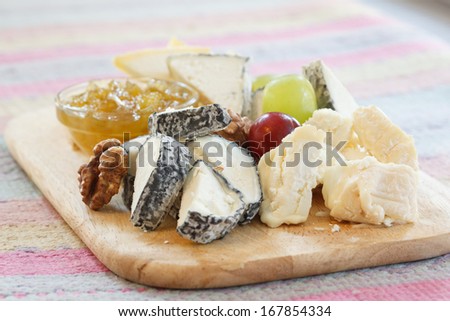 delicatessen cheeses on a wooden platter