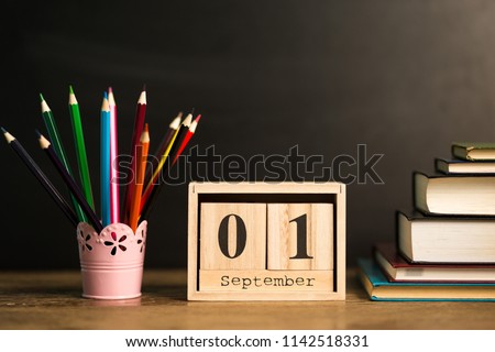 1st september set on calendar on black chalkboard background with school supplies. Back to school concept. Student workplace background