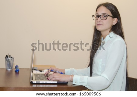 Woman with computer looking at camera with sympathetic face