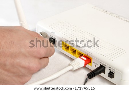 closeup of a hand connecting a modem for high speed internet