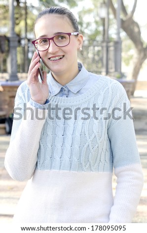Young woman with braces smiles while talking on phone