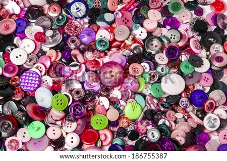 many sewing and lilac buttons stacked with white background