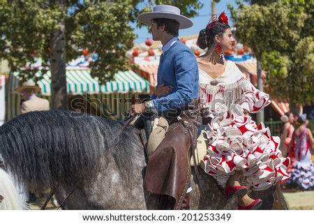 SEVILLE, SPAIN-MAY 8: People mounted on horse on fair of Seville on May 8, 2014 in Seville