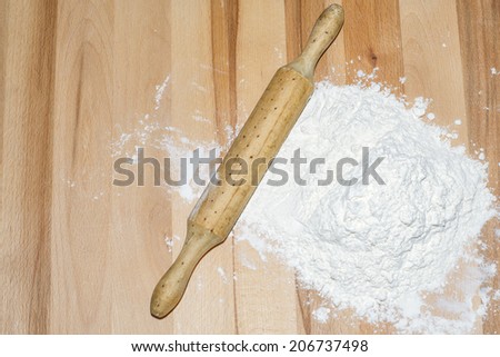Flour and rolling pin on wood, with room for text entry.