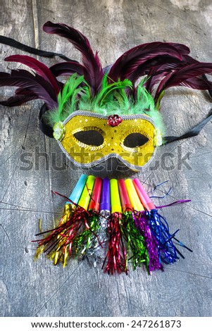 Carnival mask and blower on wood