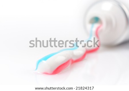 Closeup of multicolored toothpaste pouring from the tube isolated on white background.
