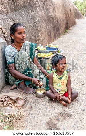 MAHABALIPURAM,INDIA - JANUARY 28,2013 - Mother with child Daha (3)from Mamallapuram selling fruit .