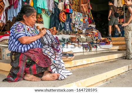 TIKAL, GUATEMALA - MARCH 19,2010 - Woman embroiders in Tikal .Hand-made products sold in markets.