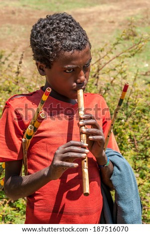 BLUE NILE, ETHIOPIA - MARCH 22,2014 - Boy playing the whistle .The boy shows how a whistle is produced and sold to tourists.