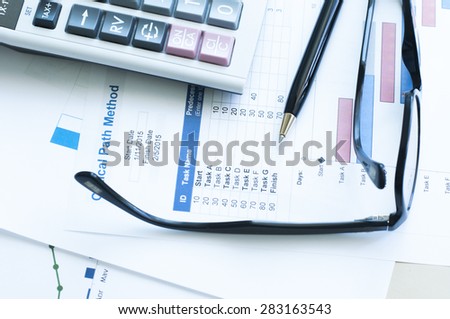 Project plan gantt chart with pen ,glass and calculator