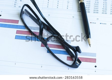 Project plan gantt chart with pen and glass