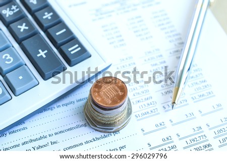 Stack of Coins with pen,calculator and financial statement background