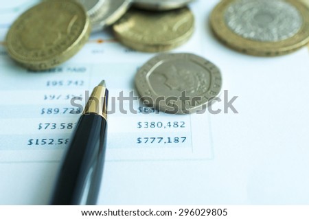 Coins with pen and financial statement background