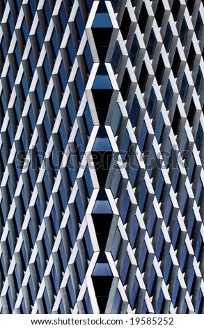 Abstract, grid shaped pattern formed by the glass and steel architectural details of a skyscraper.