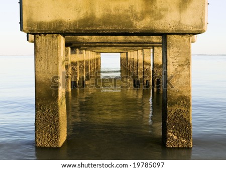 An unusual perspective from underneath the concrete base of the popular fishing pier at Lighthouse Beach on Sanibel Island, Florida, looking out over the Gulf Of Mexico.