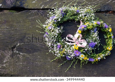 Top down view of handmade flower crowns at a barn wedding. Fresh flower headpieces on wooden table.