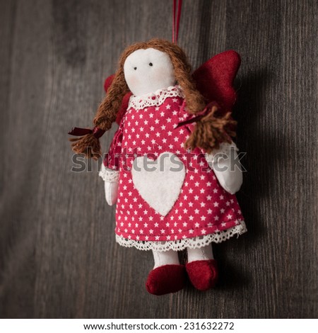 Hand made textile Girl Christmas decoration. Christmas toy. Vintage style, over wood background.