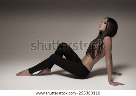 Gorgeous young woman posing in studio wearing black leggings