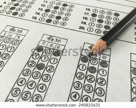 Standardized test form with answers bubbled in and a pencil resting on the paper