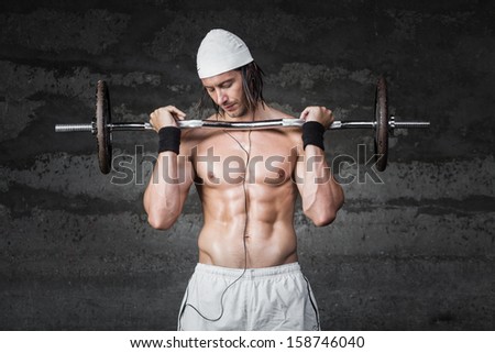 muscle bodybuilder lifting weights while listening to music