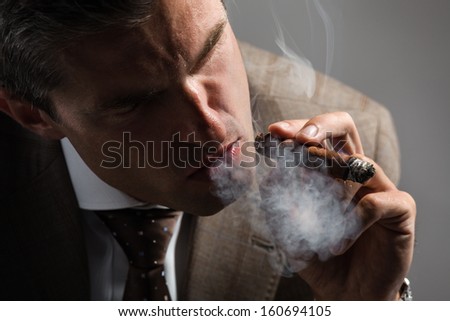 Elegant businessman smoking a cuba cigar