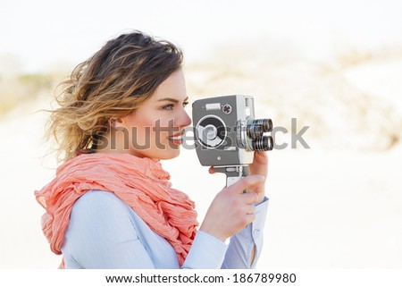 Outdoor Portrait of beautiful woman holding vintage 8mm camera