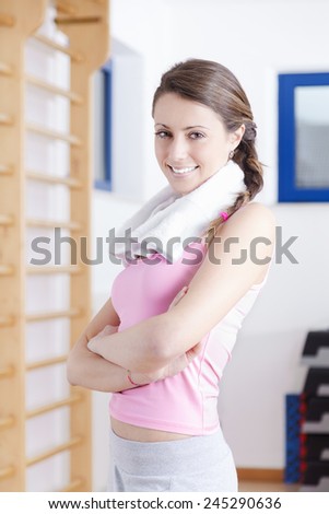 portrait of young brunette fitness woman with gym towel