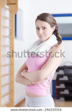 portrait of young brunette fitness woman with gym towel