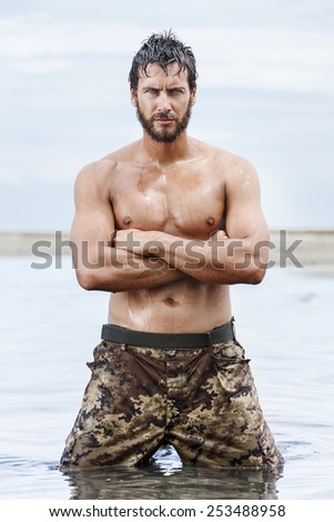 Close up Portrait of Confident Gorgeous Athletic Army with No Shirt Posing at the Sea With no Shirt.