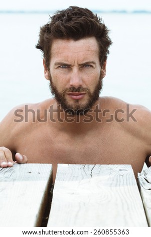 Close up Portrait of Confident Athletic Handsome Man with No Shirt Posing at the Sea