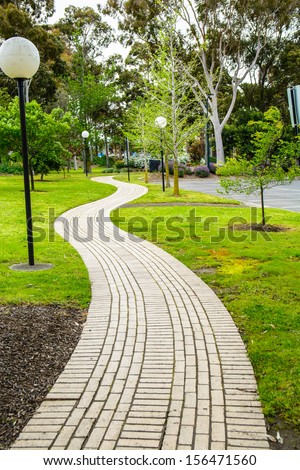A brick footpath laid from one side of the park to the other side.