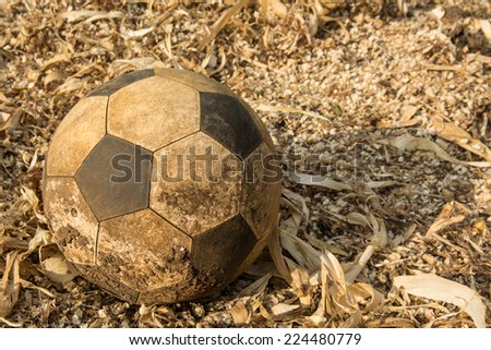 the old used football or soccer ball on the messy ground