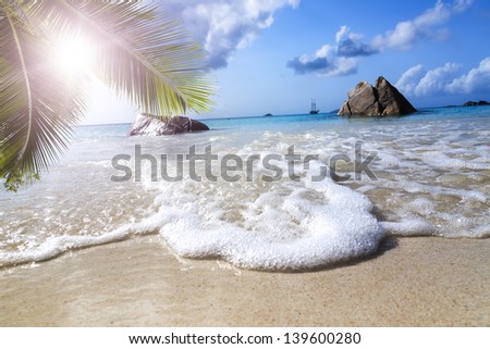 La Digue island, Seyshelles, Anse Source d\'Argent. White coral beach sand. Sailing yacht on background.