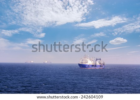 Fishing vessel for fishing in the sea. A Sunny day. Calm weather. Several ships.