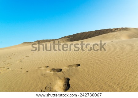 Blue sky and sand dunes with footprints. Canary islands, Maspalomas.