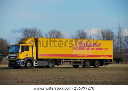 ALMERE POORT, FLEVOLAND, THE NETHERLANDS - DECEMBER 11, 2014: Parked DHL delivery truck. DHL Express is a division of Deutsche Post providing international express mail services.