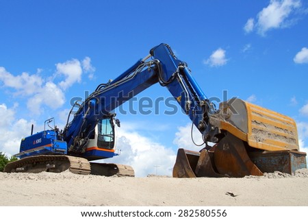 Almere, The Netherlands - May 30, 2015: Crawler Excavator Crane (earth mover) sits at rest on a sandy on a Dutch construction site