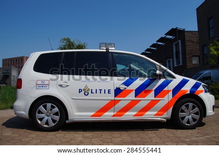 Almere Poort, Flevoland, The Netherlands - June 5, 2015: Dutch National Police Car (politie) , Volkswagen Touran, parked on a city street in front of a apartment building.