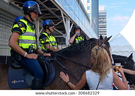Amsterdam, The Netherlands - August 22, 2015: Dutch police horse denies beer and a cigarette during Sail Amsterdam 2015 in the IJ harbor in Amsterdam.