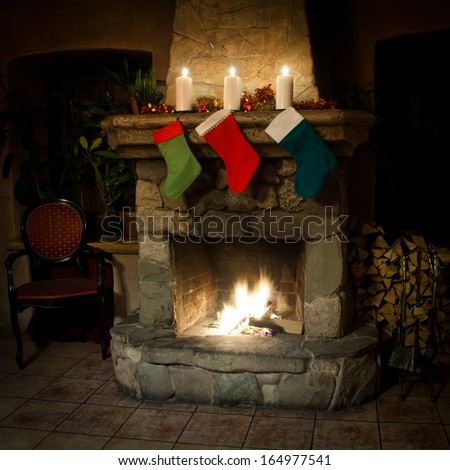 Christmas stocking on fireplace background. Chimney, candles and woodpile. Chimney place. (front view)