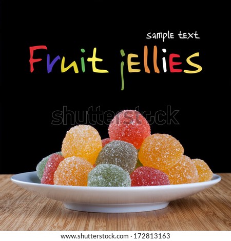Colorful fruit  jelly on a white plate. (black background and easy removable simple text)