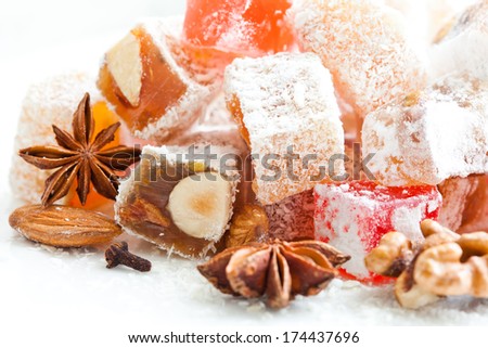 Tasty oriental sweets (Turkish delight lokum) with powdered sugar, walnut, almonds and spices.