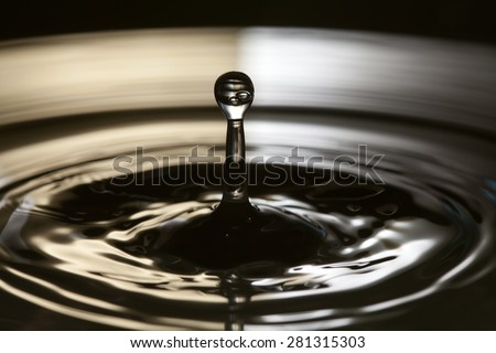 Dripping water. Liquid drops. splashing. Stylish gold, black and white background. macro view, toned photo. soft focus