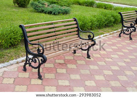 Decorative bench in public area. Grass background.