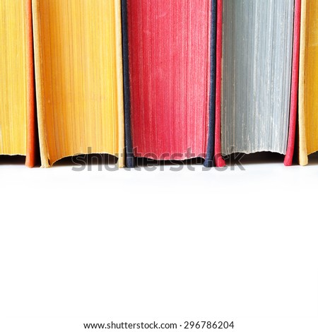 Aged colorful book spines. Close up, texture, hard cover. White background. Copy space.