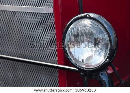 Vintage truck, bus, car headlight. Retro style auto lamp. Dark red color, chrome grill. Soft focus.